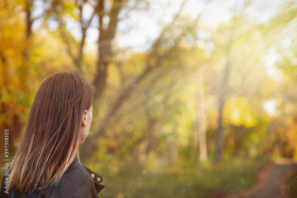 girl looks into the distance in the autumn forest with the road in the background girl looks into the distance in the autumn forest with the road in the background