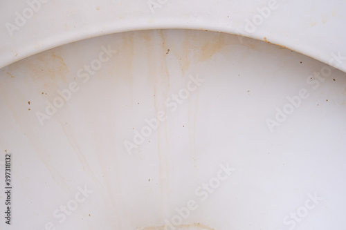 Dirty unhygienic toilet bowl with limescale stain at public restroom close up