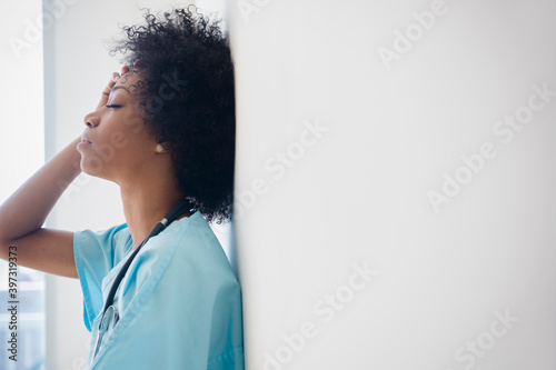 African American nurse leaning against wall