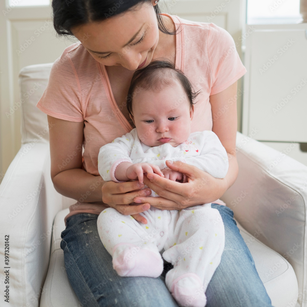 Asian mother playing with baby in living room Asian mother playing with baby in living room