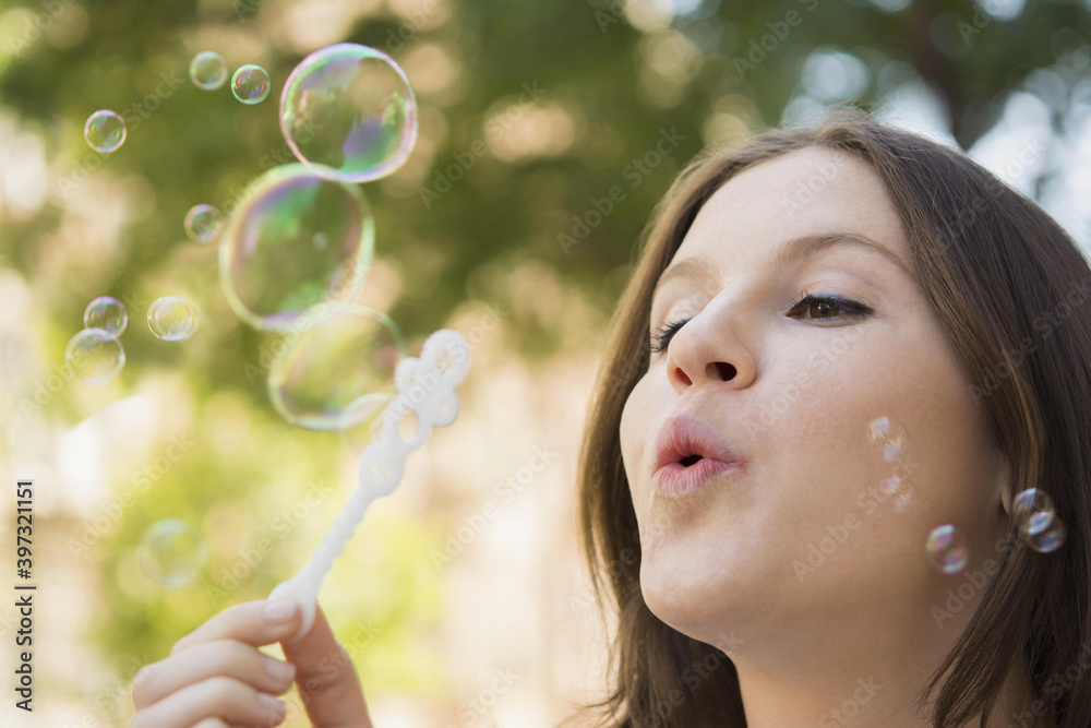 Close up of Caucasian woman blowing bubbles outdoors Close up of Caucasian woman blowing bubbles outdoors