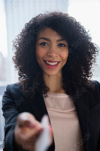 Mixed race businesswoman offering business card in office photo