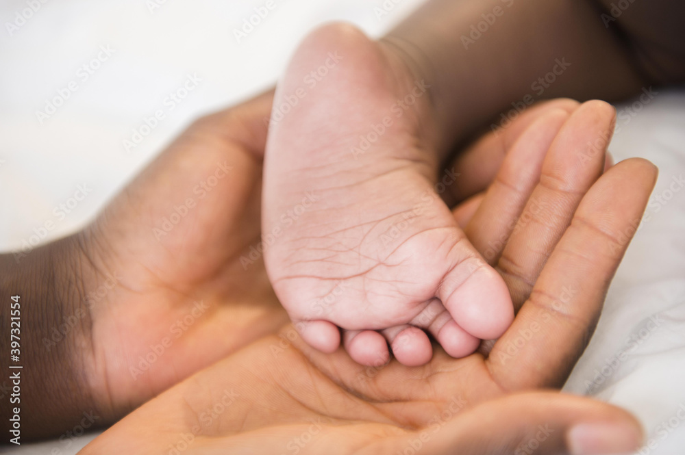 Close up of Black mother holding foot of baby Close up of Black mother holding foot of baby