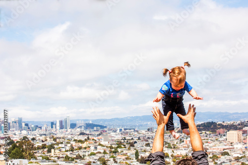 Caucasian father tossing daughter over San Francisco cityscape, California, United States photo