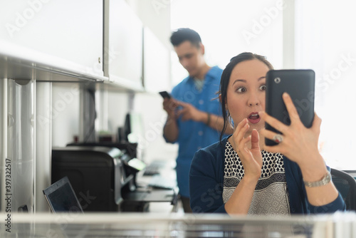 Surprised businesswoman using digital tablet in office photo