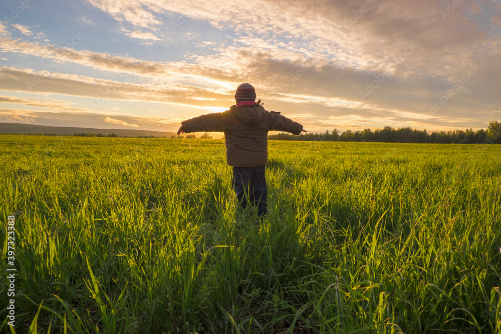 Mari boy admiring sunset in rural field Mari boy admiring sunset in rural field