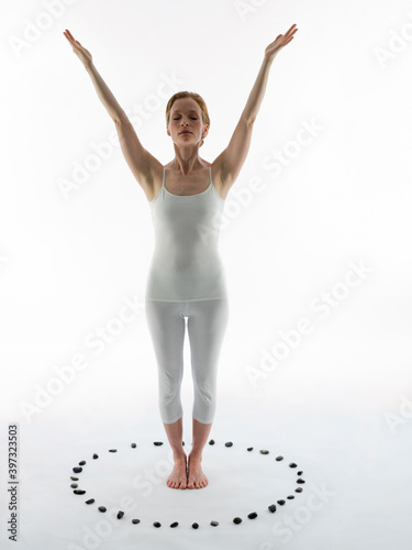 Caucasian woman practicing yoga in ring of stones photo