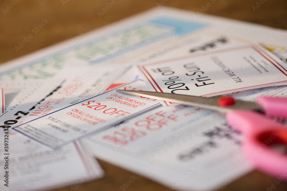 Close up of coupons and scissors on table Close up of coupons and scissors on table