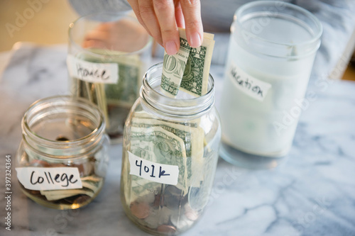 Mixed race woman saving money in jars photo