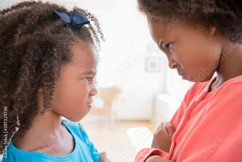 Mixed race sisters scowling