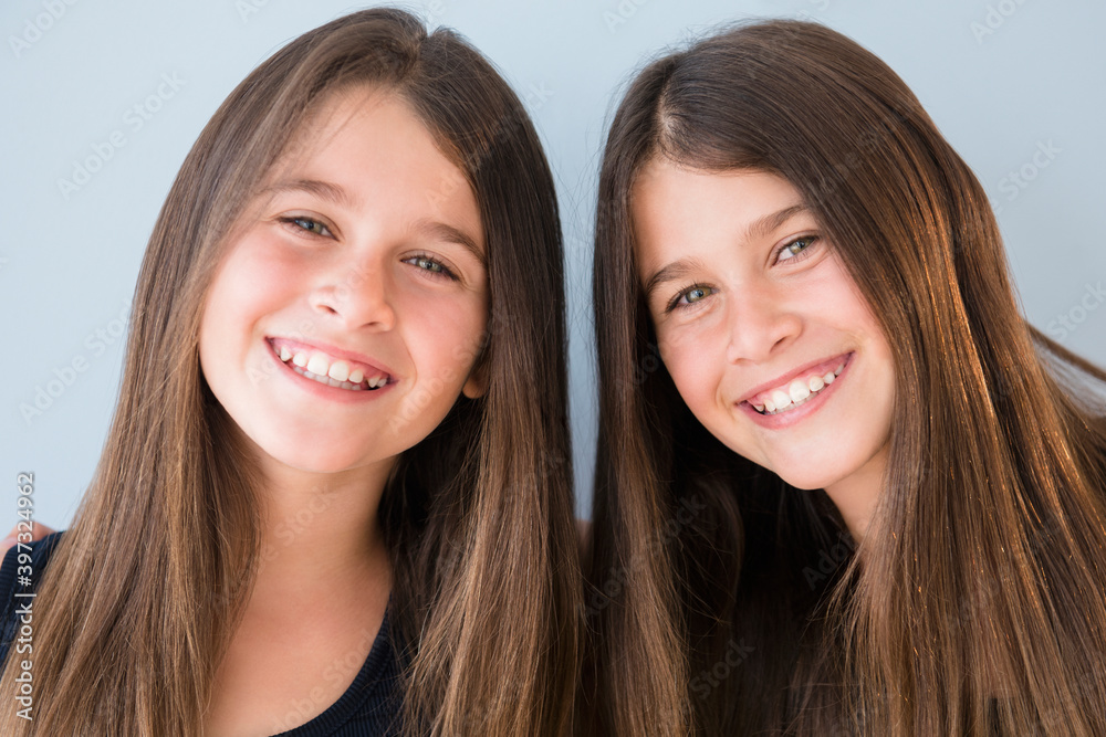 Caucasian twin sisters smiling Caucasian twin sisters smiling