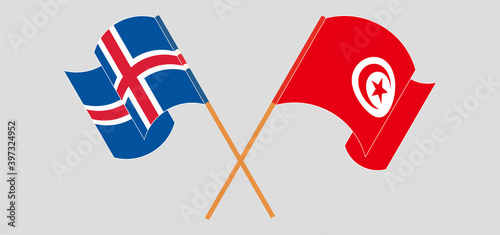 Crossed and waving flags of Iceland and Tunisia