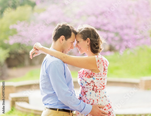 Pregnant Caucasian couple hugging outdoors
