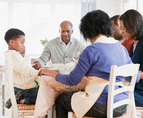 African American family praying before meal