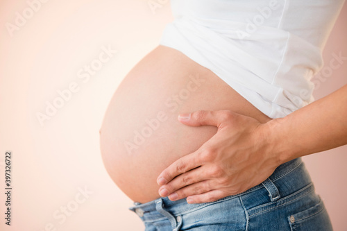 Pregnant Caucasian woman holding her belly