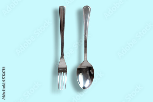 Cutlery on a blue pastel background. Spoon and fork on a pastel background.