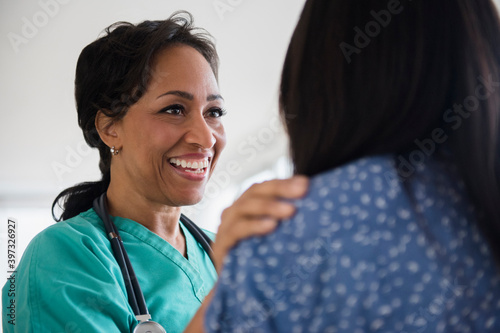 Smiling nurse comforting patient