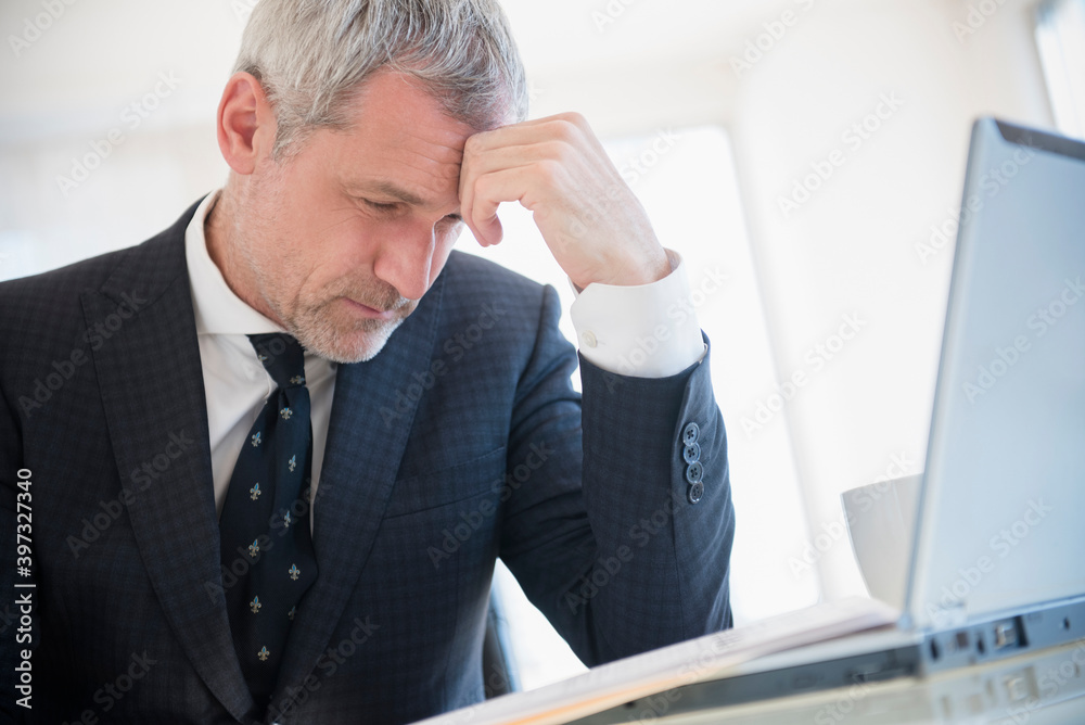 Frustrated older Caucasian businessman using laptop Frustrated older Caucasian businessman using laptop