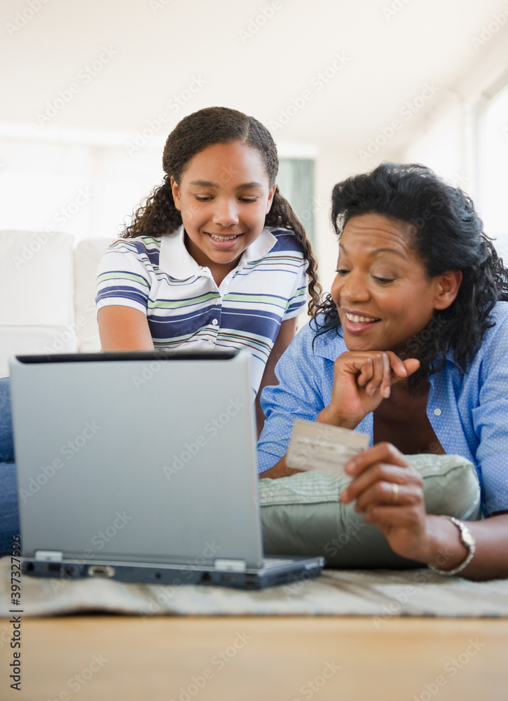 Mother and daughter using credit card online Mother and daughter using credit card online