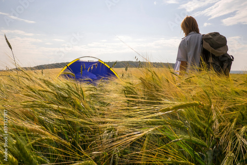 Caucasian woman standing in field near camping tent photo