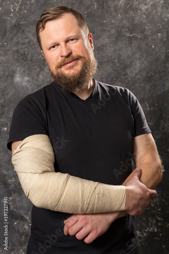 Matured man with bandaged hand studio portrait. © idea_studio