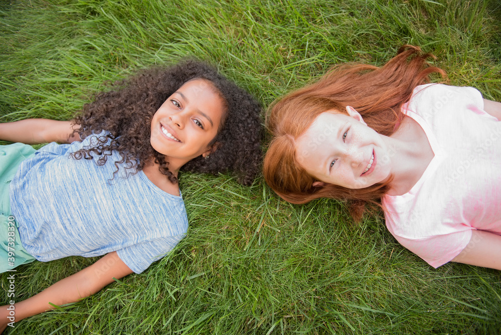 Portrait of smiling girls laying in grass Portrait of smiling girls laying in grass