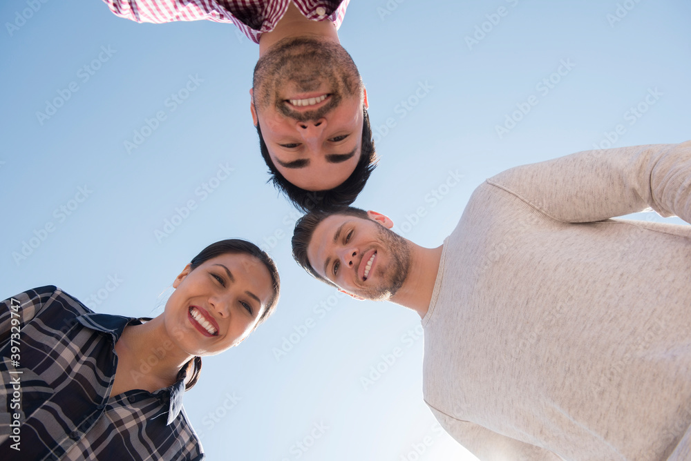 Smiling friends losing under blue sky Smiling friends losing under blue sky