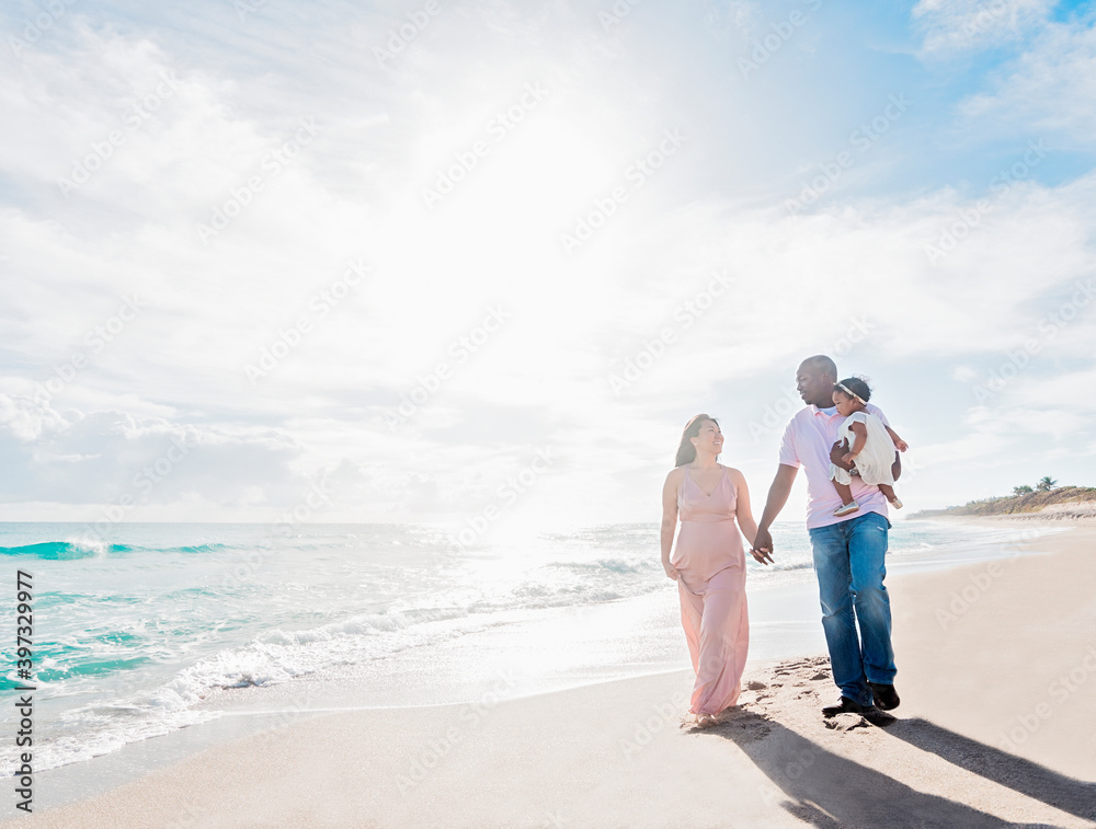 Couple walking on beach with baby daughter Couple walking on beach with baby daughter