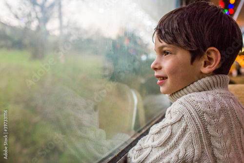Mixed Race boy looking out train window
