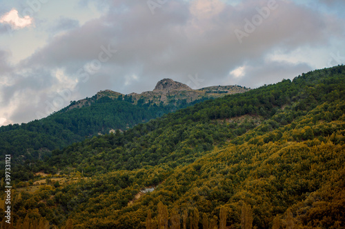 Parallel yellow mountains and cloudy sky.