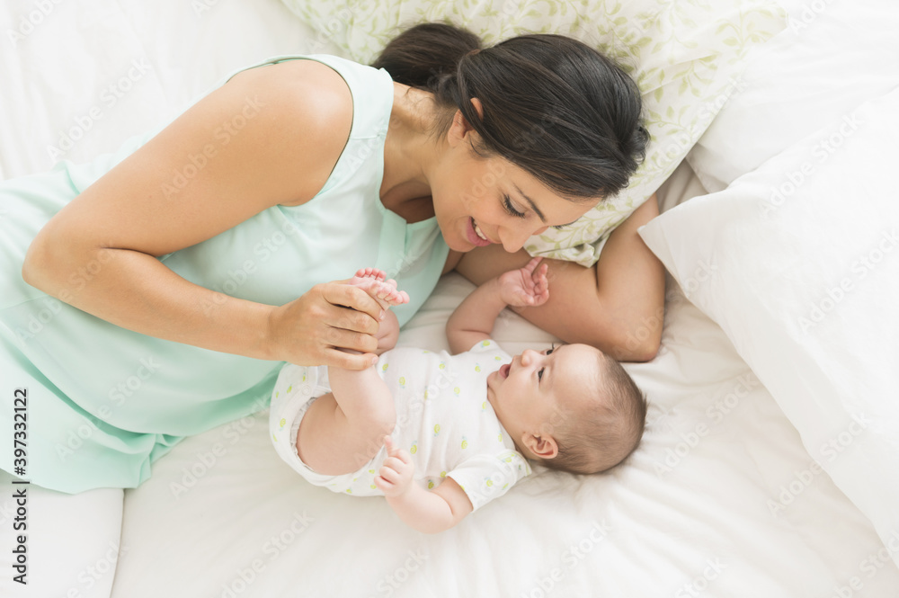 Mother and baby (2-5 months) lying on bed Mother and baby (2-5 months) lying on bed