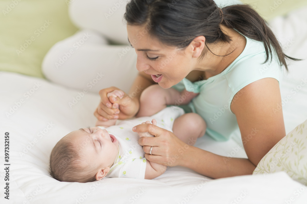 Mother and baby (2-5 months) lying on bed Mother and baby (2-5 months) lying on bed