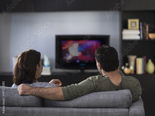 Rear view of couple watching tv