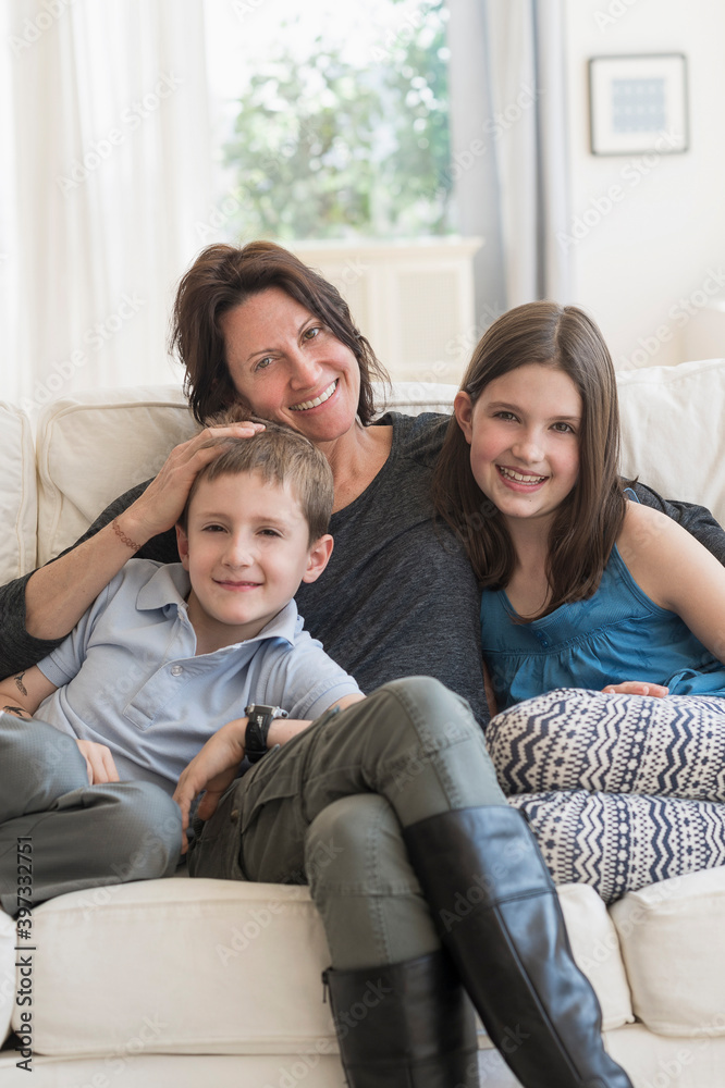 Mother and kids(8-9, 10-11) sitting on sofa Mother and kids(8-9, 10-11) sitting on sofa