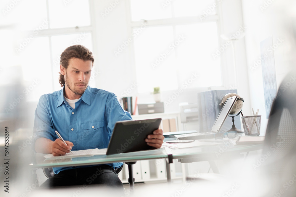 Mid-adult businessman working in office Mid-adult businessman working in office