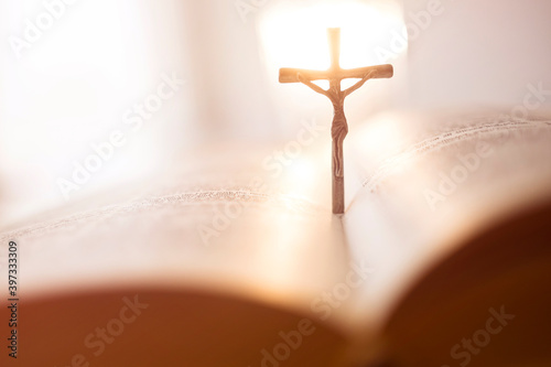 Backlit cross in open Bible