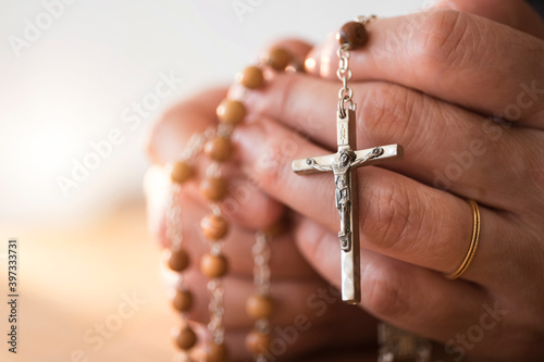 Woman praying with rosary beads in hands