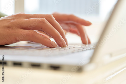 Hands typing on laptop keyboard photo