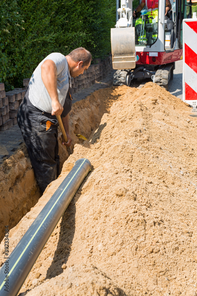 Workers installing underground optical fiber cables. Workers installing underground optical fiber cables.