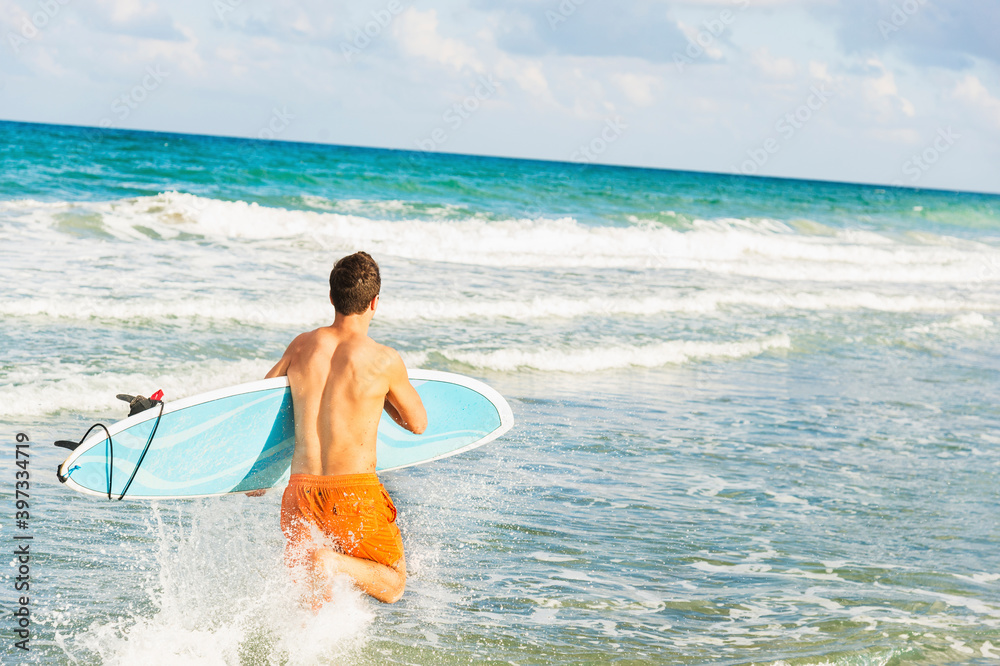 Young man carrying surfboard Young man carrying surfboard