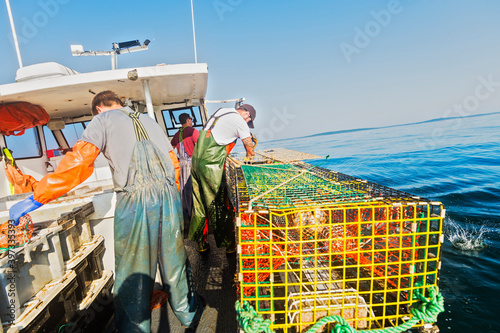 Three fishermen working on boat photo