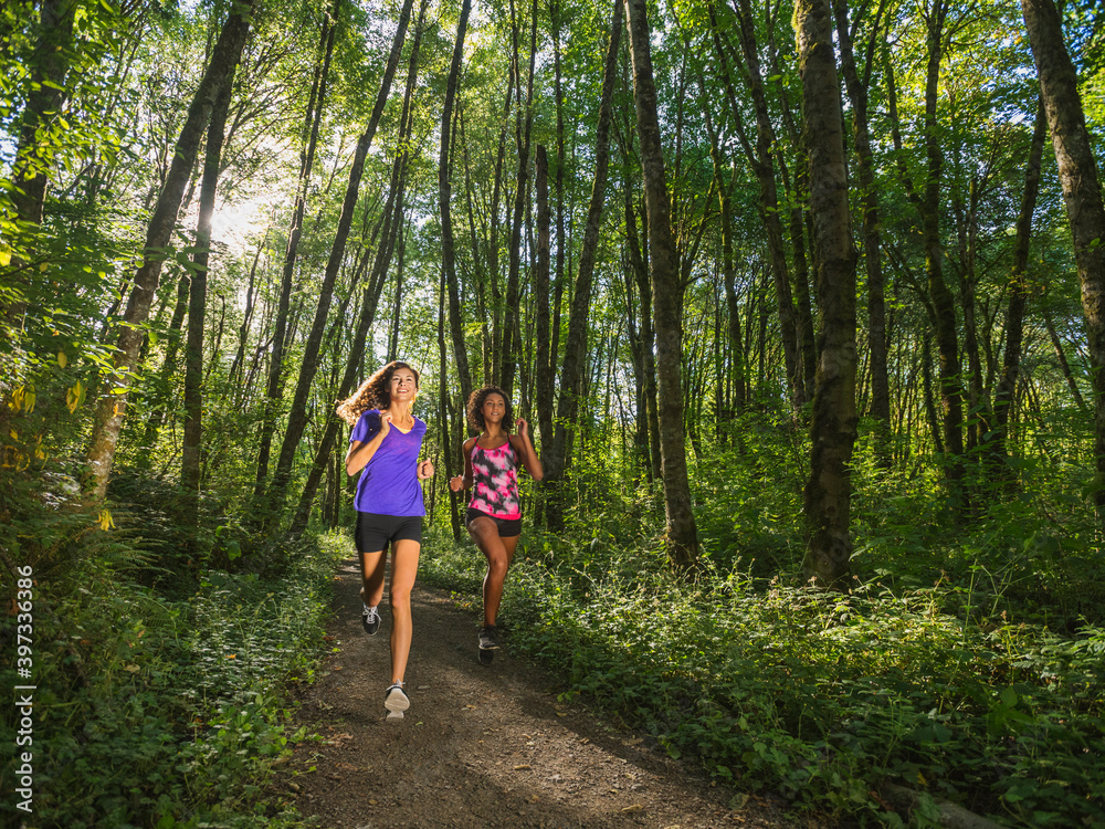 Two young women jogging in forest