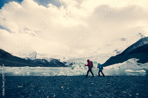 Two women hikers hiking  in winter mountains