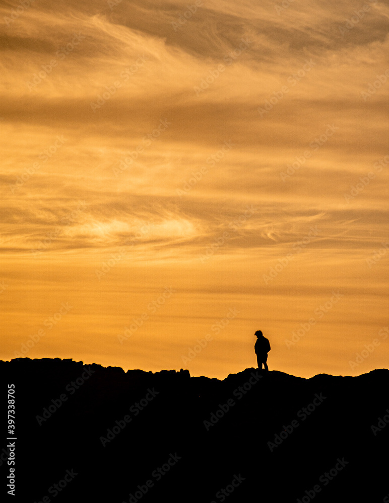 Silhouette of a lonely man at the beautiful sunset on the mountain
