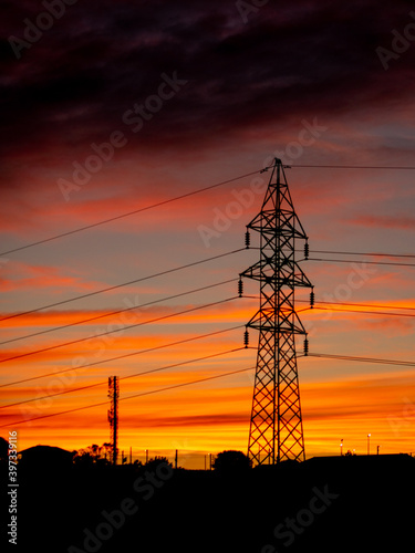 Silhouette of an electric pole at sunset