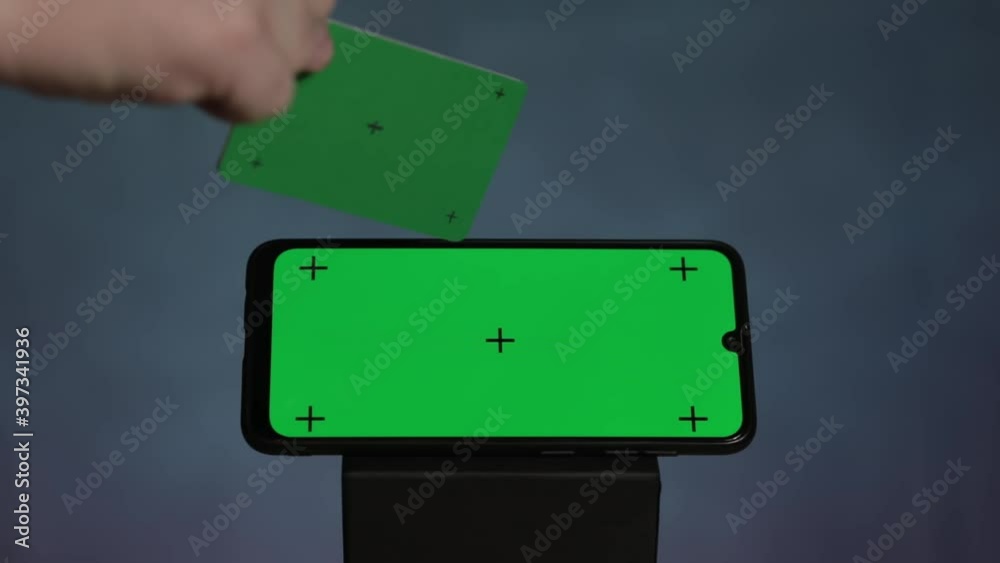 Online shopping concept. Smartphone green screen with traking points with green credit card with tracking dots moving camera on black background.
