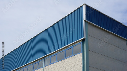 industrial warehouse building roof against sky background