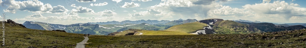 Wide panorama shot of road and hills with remains of snow in rocky mountains national park in america