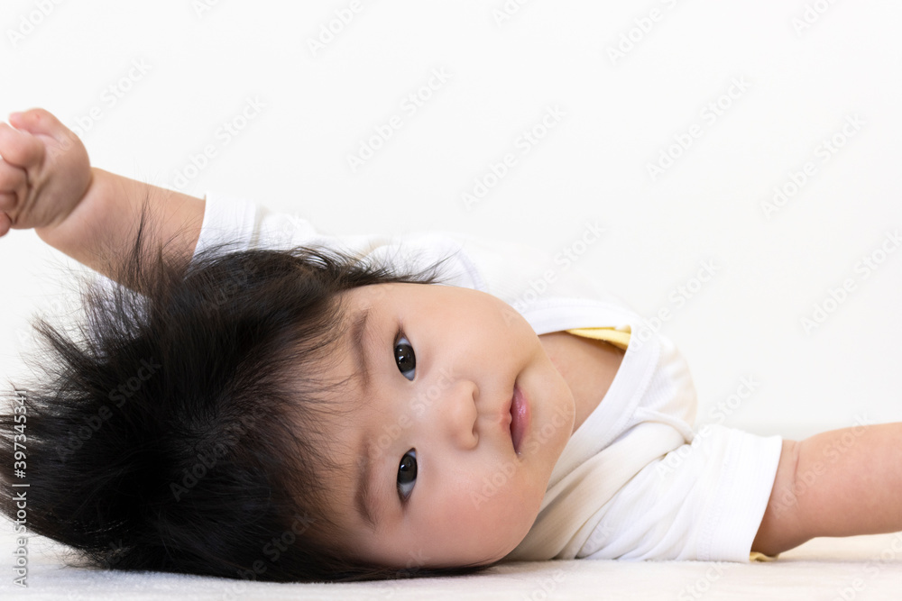 Obraz premium 仰向けでカメラ目線の赤ちゃん(0歳、生後5か月、女の子)