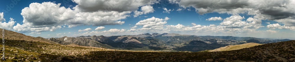Panorama shot of green rocky hills with remnants of snow in Rocky mountains national park in america